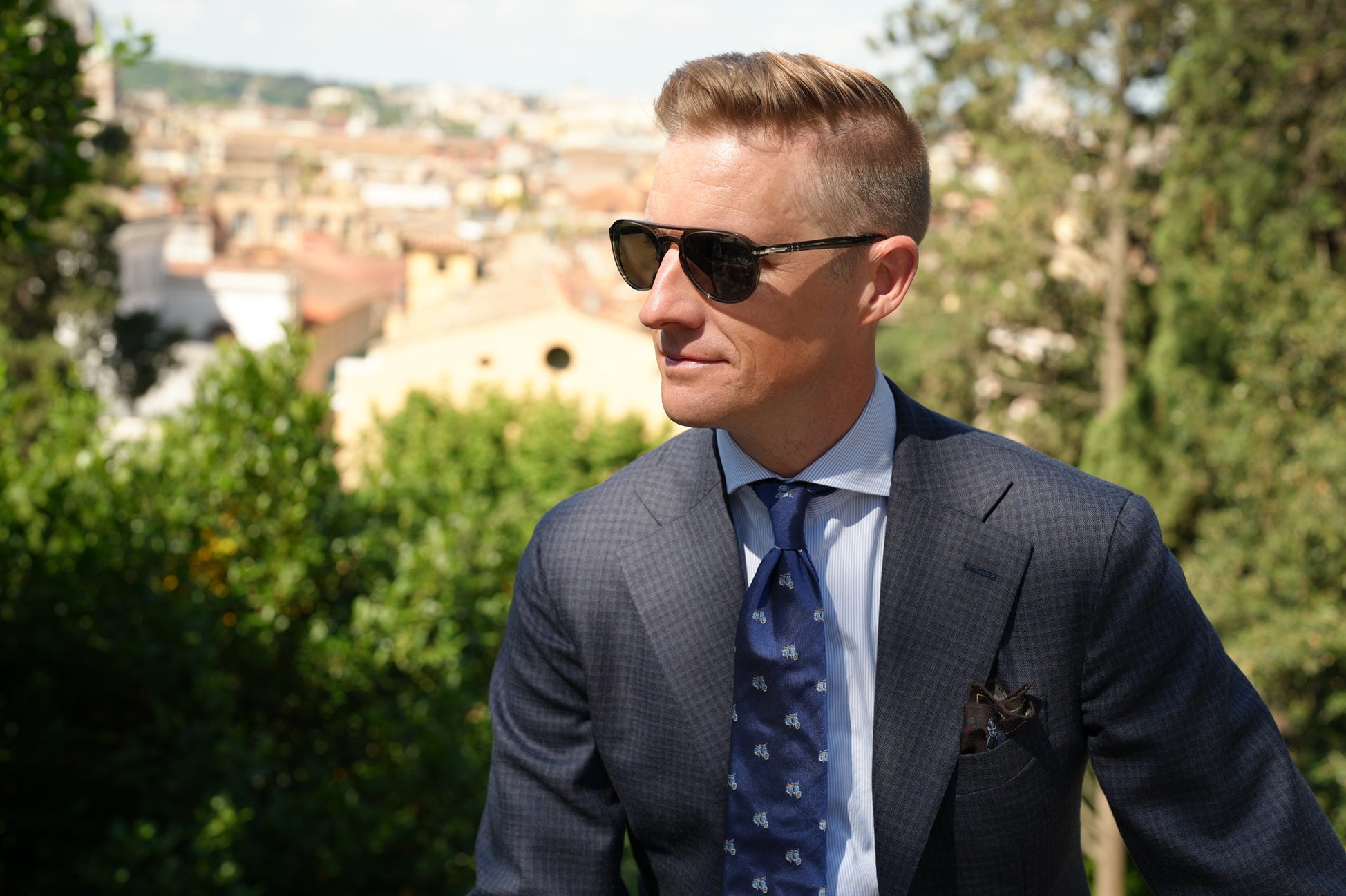 Derek in Rome in navy suit, striped blue shirt, jacquard tie